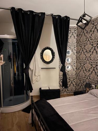 a bedroom with a bed with black curtains and a mirror at Casa Di Carla in Canino