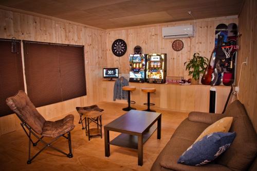 ein Wohnzimmer mit Sofa, Stühlen und einem Tisch in der Unterkunft Goodies Ella Villa & Guesthouse in Shimonoseki