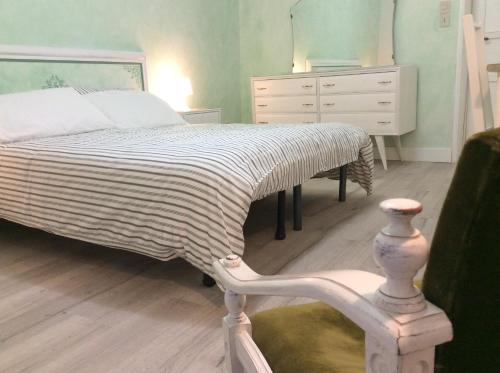 a bedroom with a bed and a dresser and a chair at Le Camere di Casa Cassandra in Perugia