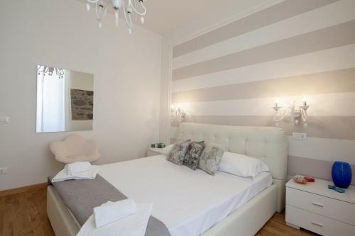 a bedroom with a large white bed with striped walls at LEO'S HOME in La Spezia