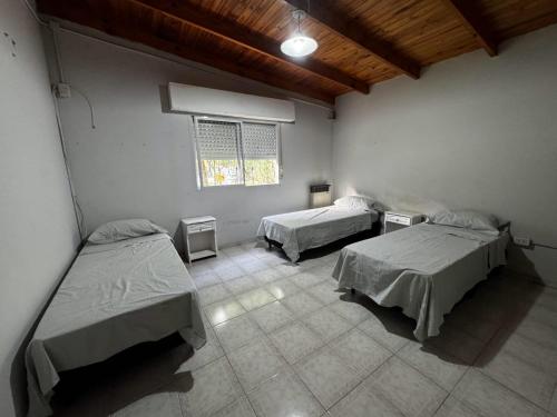a room with two beds and a window at Quinta La Soñada eventos luján in Luján