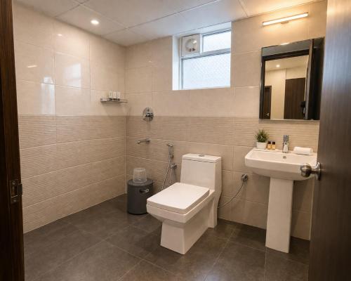 a bathroom with a toilet and a sink at Harvey's Brookefield-With Free Car Parking in Bangalore