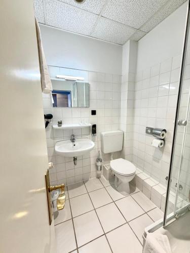 ein Badezimmer mit Toilette und Waschbecken in der Unterkunft Hotel Vorburg - Free Parking - Bei Hamburg in Trittau