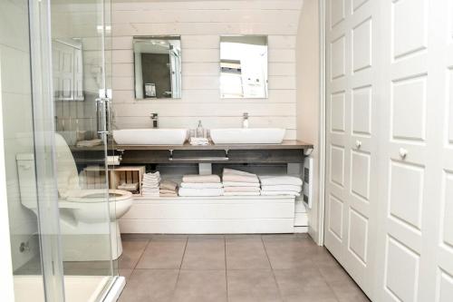a bathroom with a sink and a toilet and a mirror at Mont Ste-Anne Chalet in Beaupré