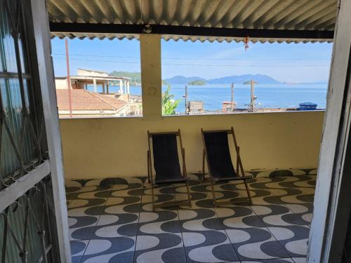 two chairs in a room with a view of the ocean at Recanto na Praia com Vista Mar in Mangaratiba