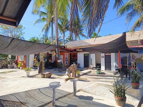 a building with palm trees in front of it at INS n OUTZ in Bolinao