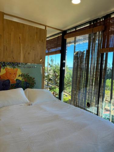 a bedroom with a white bed with a large window at Converted Farm Loft in Casablanca