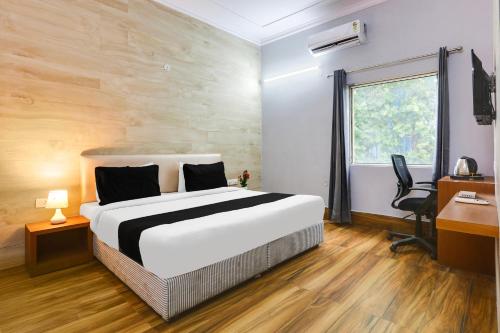 a bedroom with a bed and a desk and a window at Collection O Bhiwadi in Bhiwadi
