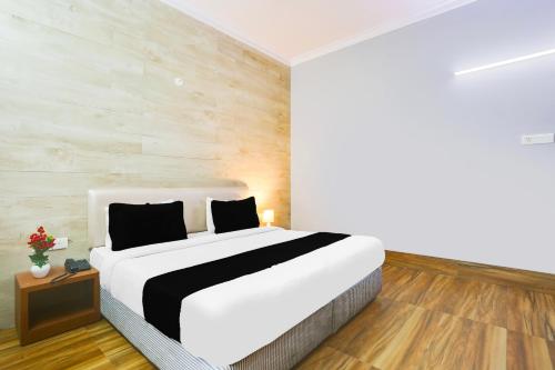a bedroom with a large white bed and wooden floors at Collection O Bhiwadi in Bhiwadi