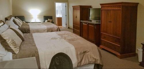 a hotel room with two beds and a television at Rolling Hills Lodge in Cherokee