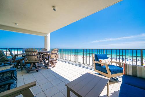 a balcony with chairs and tables on the beach at The Oasis 411 formerly Phoenix West II 411 in Orange Beach