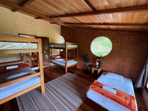 a room with two bunk beds and a brick wall at Wisdom Forest Lodge in Tena