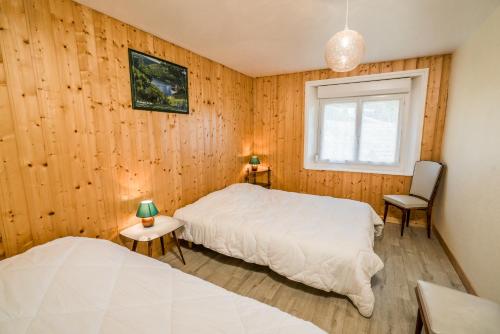 a bedroom with two beds and a window at Gites des Gentianes in Morbier