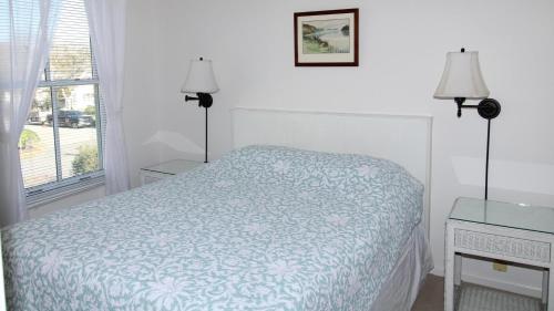 a white bedroom with a bed and a window at Somewhere In Time Unit 4 in Cape May Point