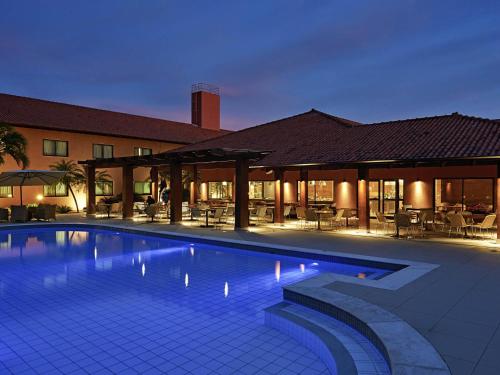 a swimming pool in front of a building at Novotel Campo Grande in Campo Grande