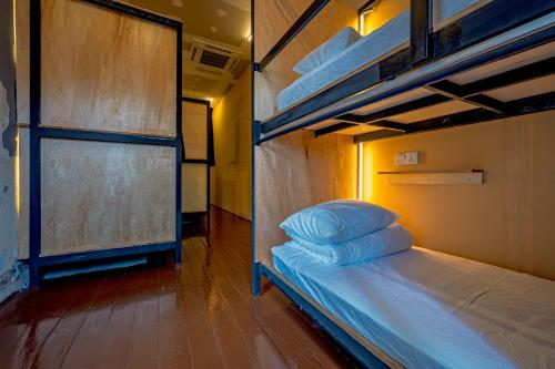 a bedroom with a bunk bed with blue pillows on it at Mingle Lekiu in Kuala Lumpur