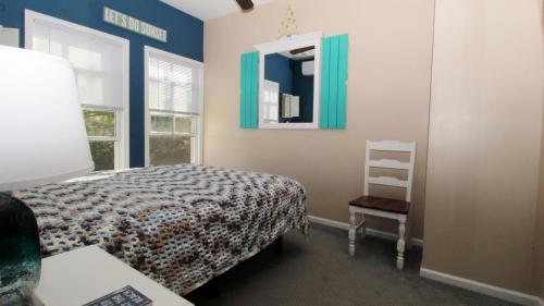 a bedroom with a bed and a chair and a mirror at 202 Ocean Unit 6 in Cape May Point