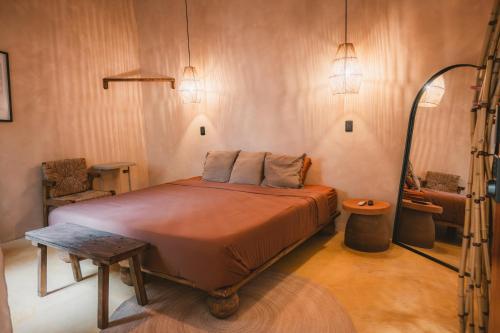 a bedroom with a bed and a chair and lights at Ánimo Perro in Sayulita