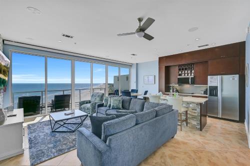 a living room with couches and a kitchen at PH, Balcony, Lazy River, I-O Pools, Game Room, Spa, Beach, Luxury 2-2 Penthouse! in Galveston