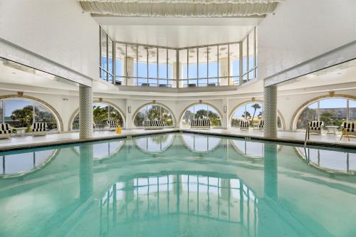 an indoor swimming pool with blue water in a building at PH, Balcony, Lazy River, I-O Pools, Game Room, Spa, Beach, Luxury 2-2 Penthouse! in Galveston