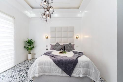 ein Schlafzimmer mit einem großen Bett in einem weißen Zimmer in der Unterkunft Soderberg By J&J Homes At Amani Grand Resort Residences Near Airport in Mactan