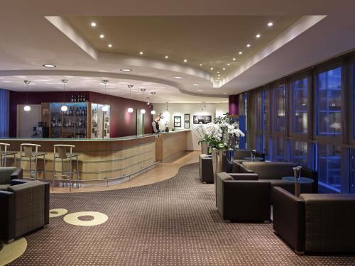 a lobby with chairs and a bar in a building at Sunday Hotel Dortmund City in Dortmund