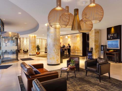 a lobby with couches and chairs in a building at Novotel London Tower Bridge in London