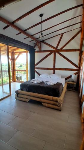 a bed in a room with a wooden ceiling at Apto/cabaña naranja in Ulloa
