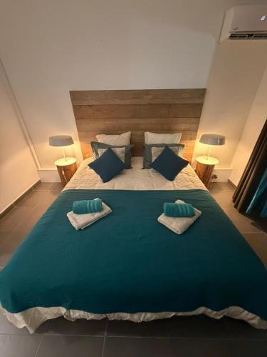 a large green bed with two pillows on it at Kéloué in Saint-François