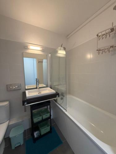 a bathroom with a sink and a mirror and a tub at Kéloué in Saint-François