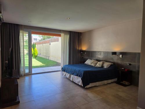 a bedroom with a bed and a large sliding glass door at Espectacular Casa con pileta y jacuzzi in San Juan