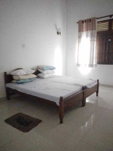 a bed in a white room with a window at Green Haven by Gapper Sri Lanka in Wattala