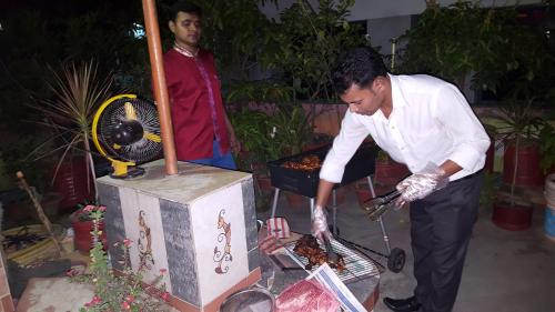 a man cooking food on top of a grill at Babylon Hotel & Serviced Apartment in Dhaka