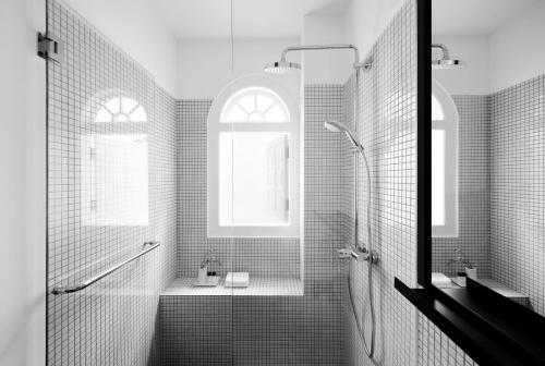 a black and white bathroom with a shower and a sink at Hotel Mono in Singapore