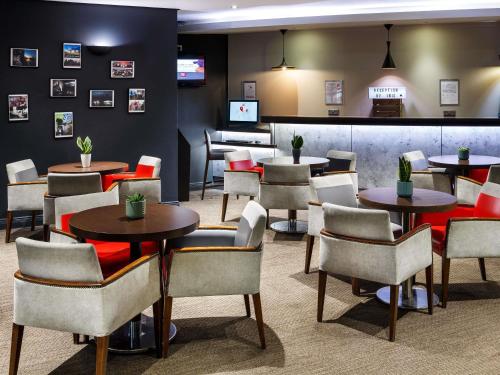 a restaurant with tables and chairs and a bar at ibis Glasgow City Centre – Sauchiehall St in Glasgow