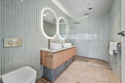 a bathroom with two sinks and a mirror at Mirani's Penthouse in Port Adelaide
