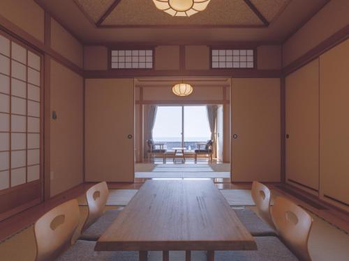 a dining room with a wooden table and chairs at TOYA Station Villa in Lake Toya