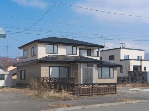 a house with a black roof on top of it at TOYA Station Villa in Lake Toya