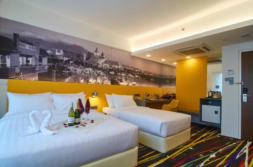 a hotel room with two beds and a desk at Amerin Hotel Johor Bahru in Johor Bahru