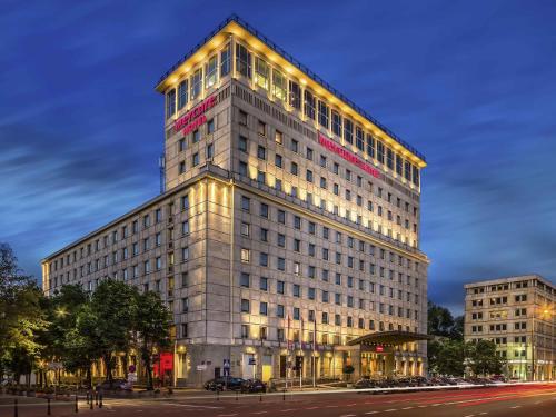 a tall building with lights on the side of it at Mercure Warszawa Grand in Warsaw