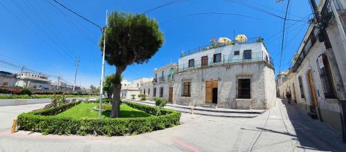 an old building with a tree in the middle of a street at Casa El Errante in Arequipa