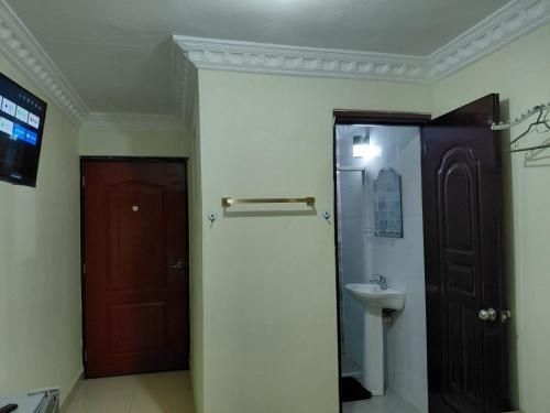 a bathroom with a toilet and a sink and a door at BNB Habitaciones Economicas - Cerca Aeropuerto Las Americas in La Viva