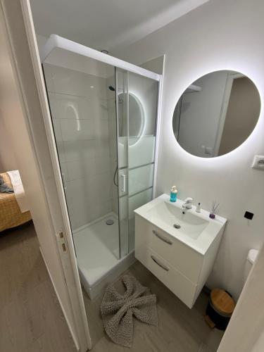 a white bathroom with a shower and a sink at Suites Confort Paris & Orly in Villeneuve-Saint-Georges