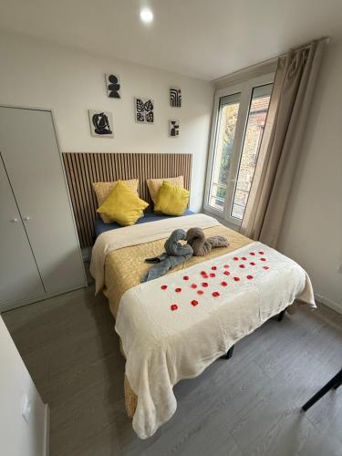 a bedroom with a bed with red hearts on it at Suites Confort Paris & Orly in Villeneuve-Saint-Georges