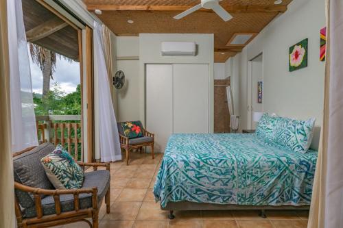 a bedroom with a bed and a balcony at Tipani Villa Sovereign Palms CI in Rarotonga