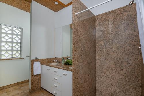 a bathroom with a shower and a sink at Tipani Villa Sovereign Palms CI in Rarotonga