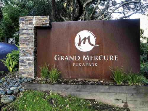 a sign for the grand mercure pula park at Grand Mercure Puka Park Resort in Pauanui