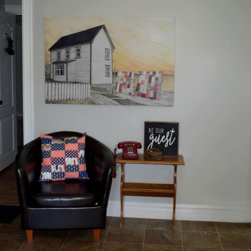 a living room with a chair and a picture of a house at Parkers Blue Water Inn in Pilleyʼs Island