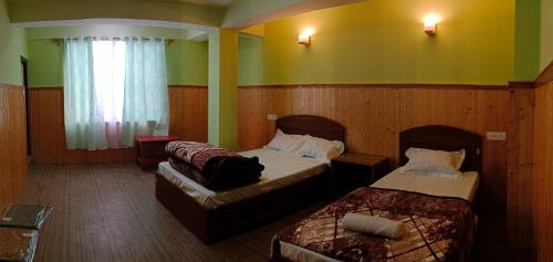 a hotel room with two beds and a couch at Hotel Sunrise in Lachen