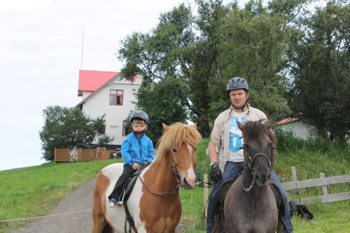 een man en een kind die paardrijden met een man bij Ferðaþjónustan Geitaskarði in Geitaskard